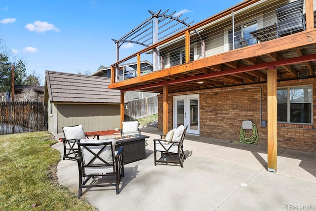 view of patio / terrace with outdoor lounge area, an outbuilding, french doors, and fence