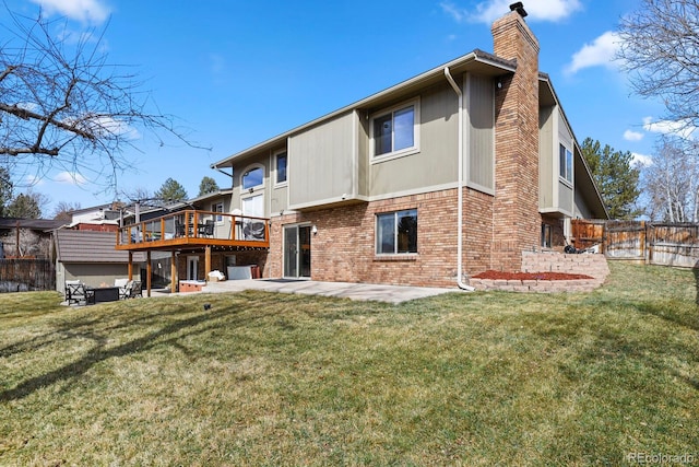 rear view of house with fence, a chimney, a patio area, a lawn, and brick siding