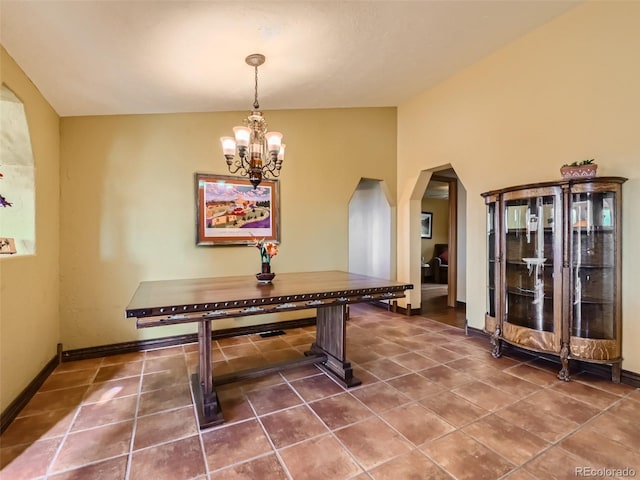 rec room with baseboards, a chandelier, arched walkways, and dark tile patterned flooring