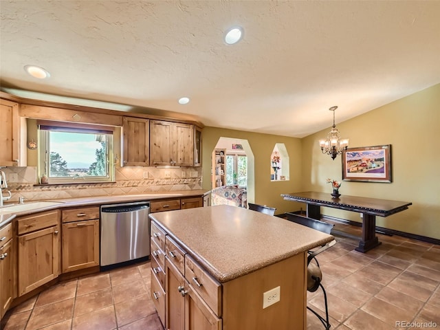 kitchen featuring a kitchen island, a sink, a kitchen breakfast bar, decorative backsplash, and dishwasher