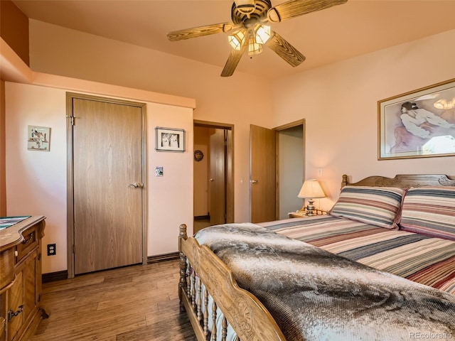 bedroom with ceiling fan, a closet, baseboards, and wood finished floors