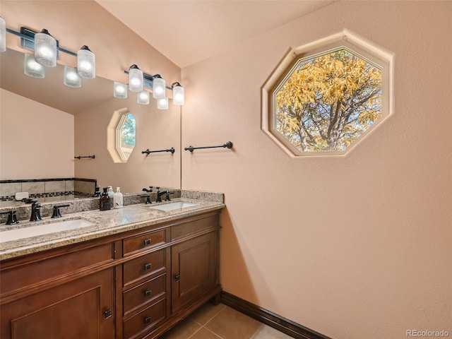 full bath featuring tile patterned flooring, a sink, baseboards, and double vanity