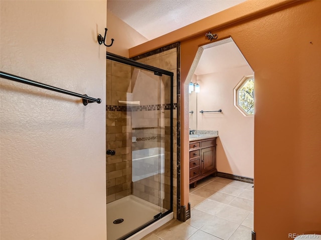 full bathroom with baseboards, a stall shower, vanity, and tile patterned floors