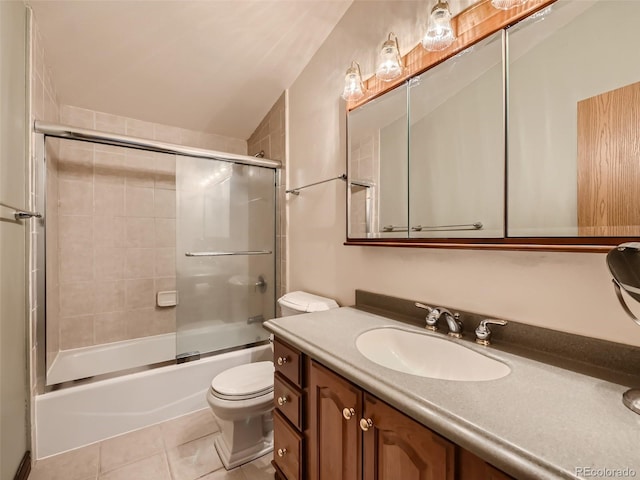 bathroom with combined bath / shower with glass door, vanity, toilet, and tile patterned floors