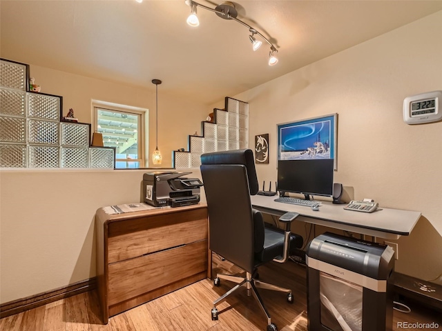 office space with track lighting and wood finished floors