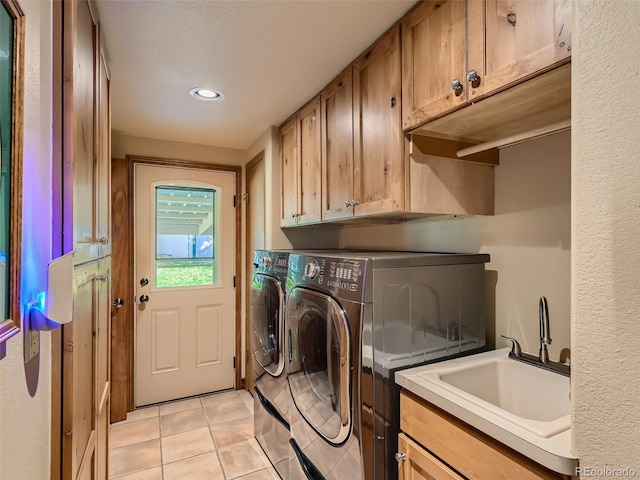 laundry area featuring independent washer and dryer, cabinet space, a sink, and light tile patterned flooring