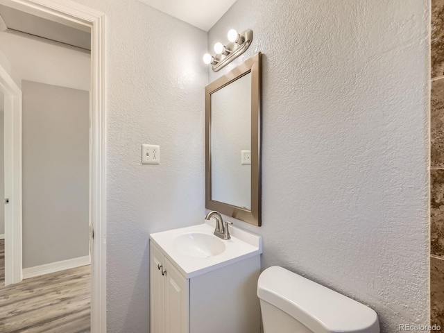 1731 Uinta St, Denver, CO 80220 - half bathroom featuring vanity, wood finished floors, and a textured wall