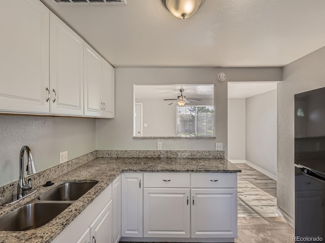 1731 Uinta St, Denver, CO 80220 - kitchen with a ceiling fan, white cabinetry, stone countertops, and freestanding refrigerator
