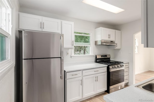 1780 Alton St, Aurora, CO 80010 - kitchen with stainless steel appliances, under cabinet range hood, white cabinetry, and light countertops