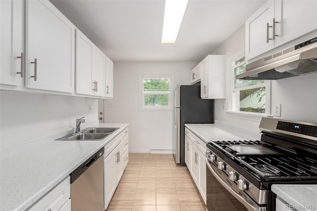 1780 Alton St, Aurora, CO 80010 - kitchen featuring appliances with stainless steel finishes, under cabinet range hood, white cabinetry, light tile patterned floors, and light stone counters