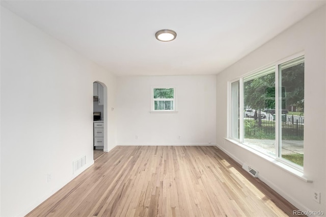 1780 Alton St, Aurora, CO 80010 - unfurnished room with arched walkways, plenty of natural light, and light wood-style floors