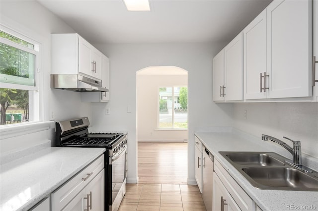 1780 Alton St, Aurora, CO 80010 - kitchen with stainless steel appliances, under cabinet range hood, healthy amount of natural light, and arched walkways