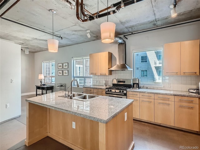 kitchen with backsplash, sink, stainless steel range with gas cooktop, and wall chimney exhaust hood