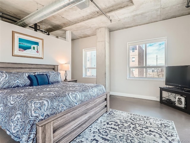 bedroom with multiple windows and concrete flooring