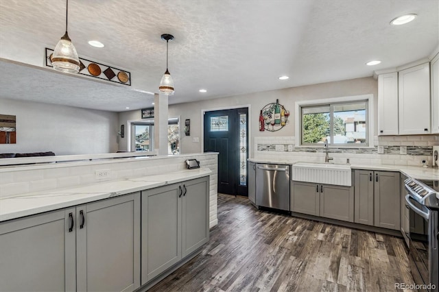 kitchen featuring hanging light fixtures, gray cabinets, and stainless steel appliances