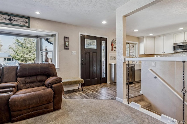 entrance foyer featuring a textured ceiling and carpet flooring