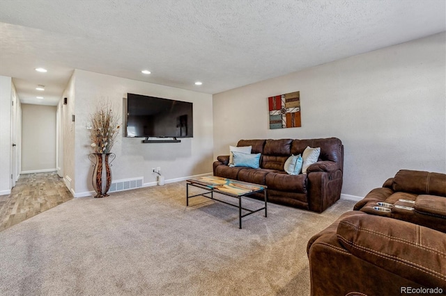 living room featuring light carpet and a textured ceiling