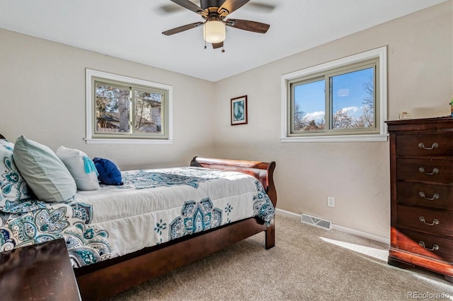 carpeted bedroom with multiple windows and ceiling fan