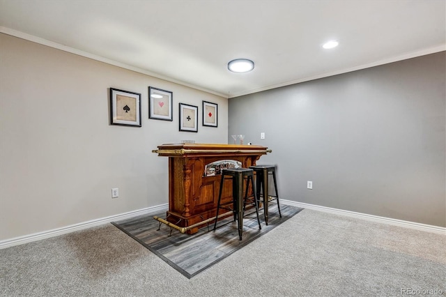 bar with crown molding and dark colored carpet