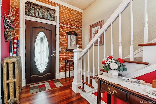 912 S Washington St, Denver, CO 80209 - entrance foyer featuring stairway, wood finished floors, radiator, ornamental molding, and brick wall