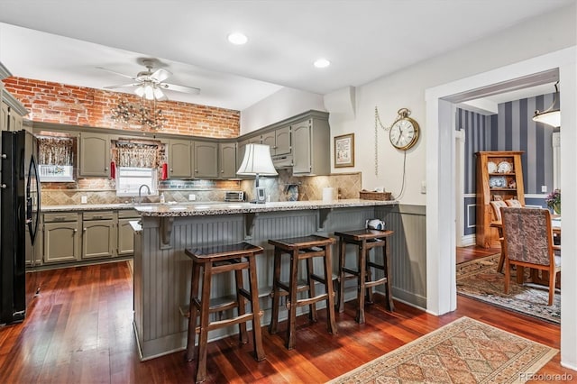912 S Washington St, Denver, CO 80209 - kitchen featuring freestanding refrigerator, a peninsula, a ceiling fan, a breakfast bar area, and a wainscoted wall