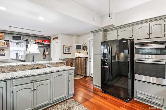 912 S Washington St, Denver, CO 80209 - kitchen with black refrigerator with ice dispenser, double oven, gray cabinets, and wood finished floors