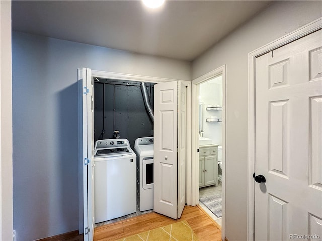 laundry area with laundry area, light wood-type flooring, and independent washer and dryer