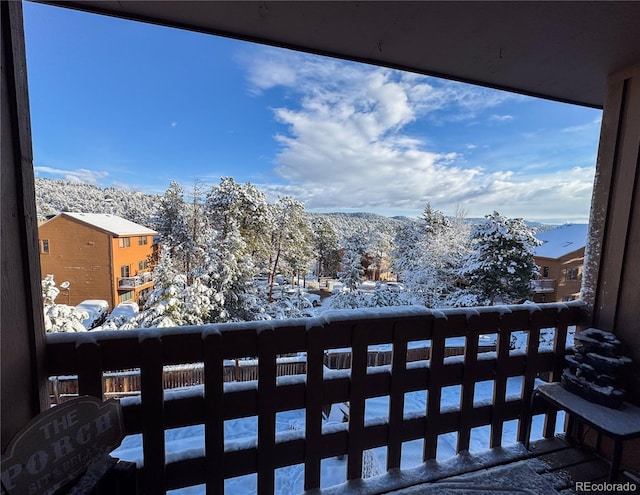 snow covered back of property with a mountain view