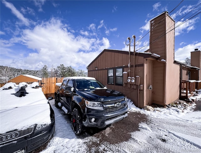 snow covered parking area with fence