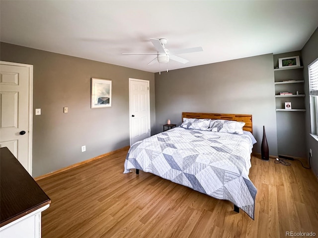 bedroom featuring light wood-style floors, baseboards, and a ceiling fan