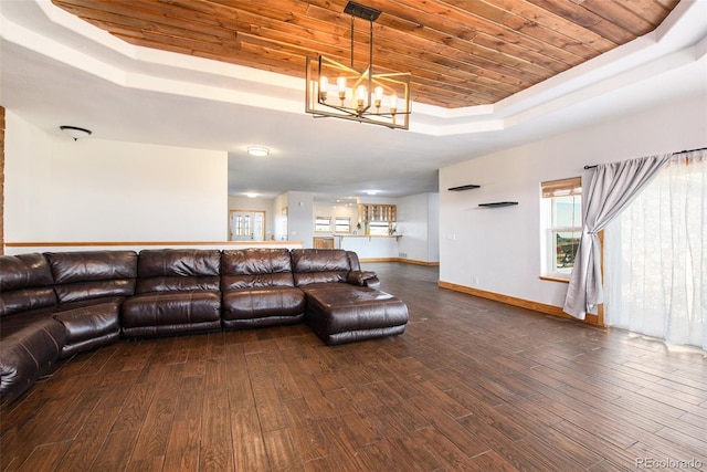 living room featuring a raised ceiling, wood ceiling, dark wood-type flooring, and a notable chandelier