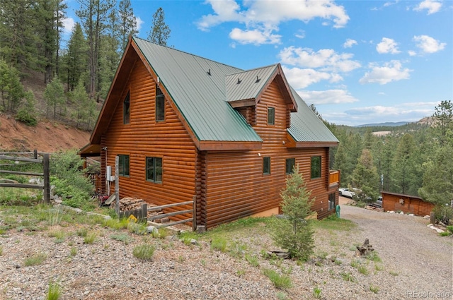 27264 Schuyler Gulch Rd, Pine, CO 80470 - view of side of property featuring metal roof, log siding, gravel driveway, and a view of trees