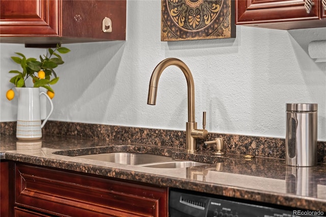 room details featuring reddish brown cabinets, dishwasher, a textured wall, dark countertops, and a sink