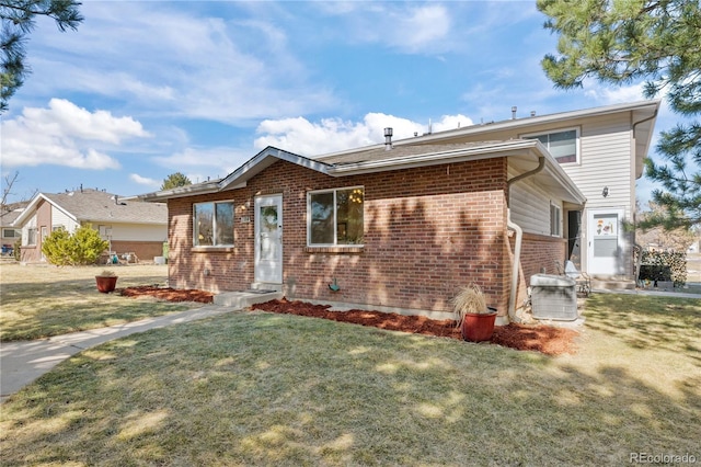 single story home featuring a front yard and brick siding