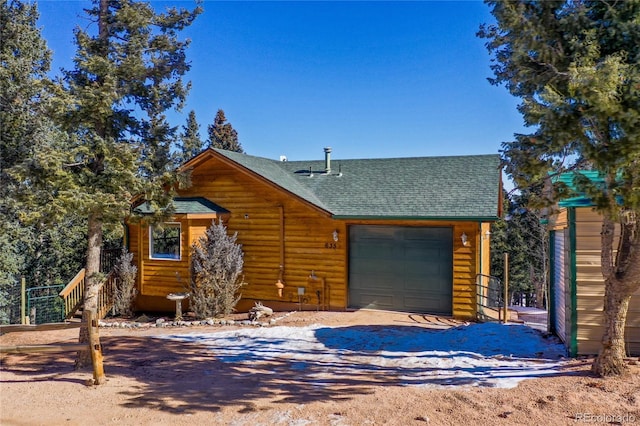 view of front of property featuring an attached garage, driveway, and roof with shingles