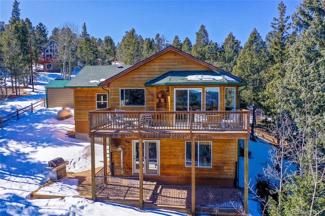 snow covered property with a wooden deck