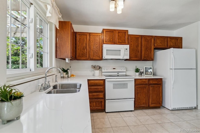 8625 W Dartmouth Pl, Lakewood, CO 80227 - kitchen with white appliances, a sink, light countertops, and light tile patterned flooring