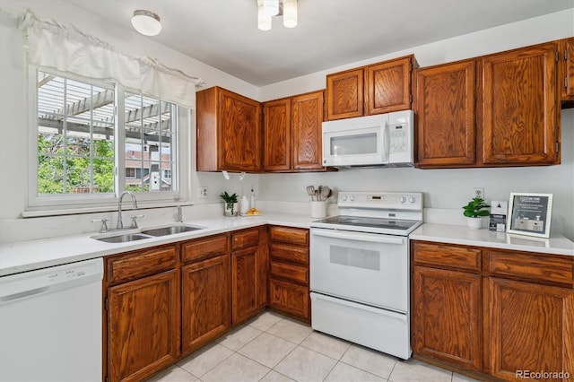 8625 W Dartmouth Pl, Lakewood, CO 80227 - kitchen featuring white appliances, a sink, light countertops, and light tile patterned floors