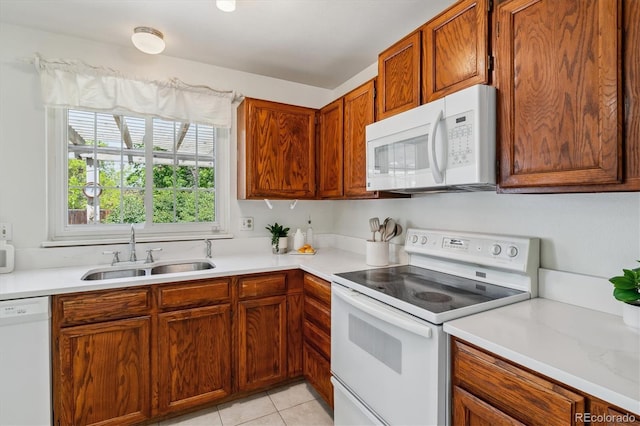 8625 W Dartmouth Pl, Lakewood, CO 80227 - kitchen featuring white appliances, a sink, light countertops, and light tile patterned floors