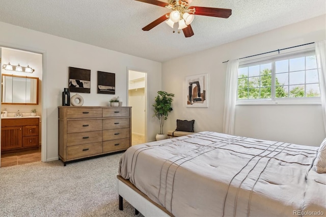 8625 W Dartmouth Pl, Lakewood, CO 80227 - bedroom with a walk in closet, a textured ceiling, light carpet, a sink, and a ceiling fan