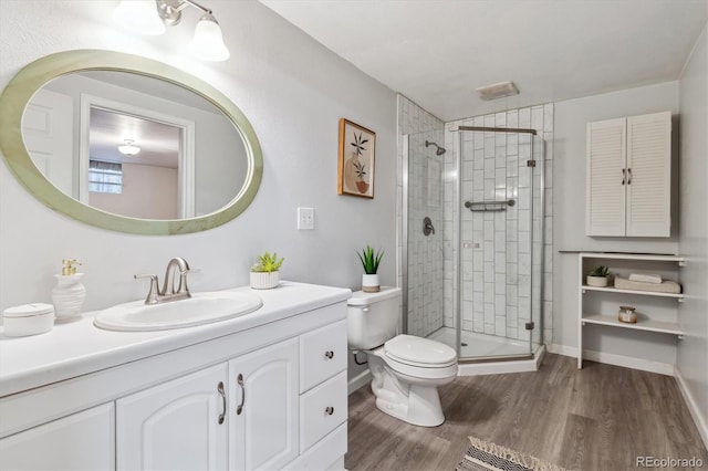 8625 W Dartmouth Pl, Lakewood, CO 80227 - full bathroom featuring a stall shower, toilet, wood finished floors, and vanity