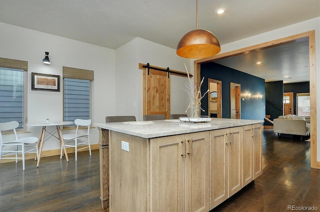 656 S Gunnison Ave, Buena Vista, CO 81211 - kitchen with dark wood-style flooring, light brown cabinetry, a barn door, a center island, and decorative light fixtures