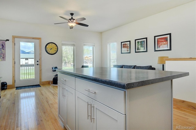 656 S Gunnison Ave, Buena Vista, CO 81211 - kitchen with a wealth of natural light, dark countertops, light wood-style flooring, and a center island