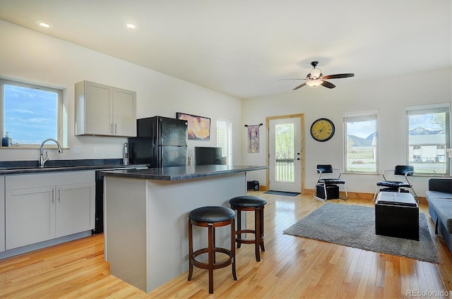 656 S Gunnison Ave, Buena Vista, CO 81211 - kitchen with freestanding refrigerator, a breakfast bar area, open floor plan, a sink, and dark countertops