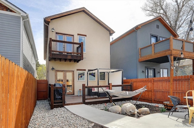 656 S Gunnison Ave, Buena Vista, CO 81211 - rear view of property featuring a balcony, a fenced backyard, stucco siding, a deck, and french doors