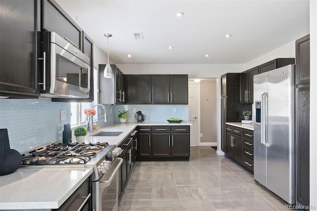 kitchen featuring tasteful backsplash, sink, pendant lighting, and premium appliances