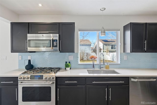 kitchen featuring decorative light fixtures, sink, stainless steel appliances, and tasteful backsplash