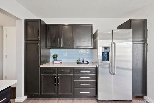 kitchen with decorative backsplash, stainless steel fridge with ice dispenser, light hardwood / wood-style flooring, and dark brown cabinetry