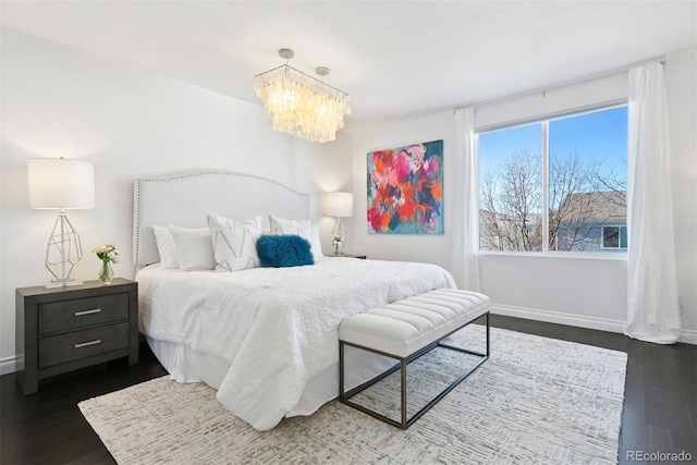 bedroom with dark hardwood / wood-style flooring and a chandelier