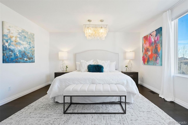 bedroom with a chandelier and dark hardwood / wood-style flooring